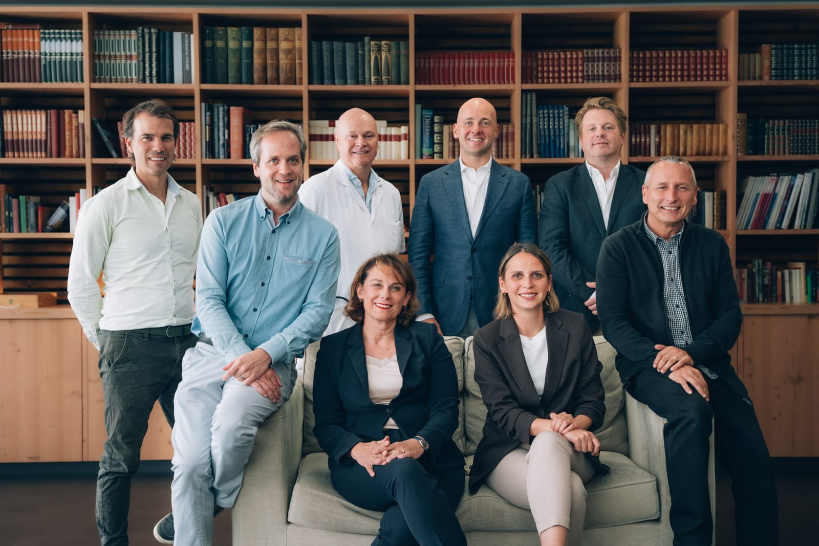 Photo de groupe : neuf membres de l’équipe, assis et debout, devant le mur de livres de la clinique